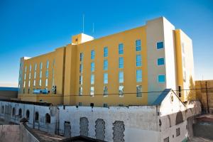 Apizaco的住宿－阿皮薩科城市快捷酒店，一座大型黄色建筑,位于一座建筑的顶部