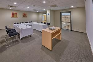 einen Konferenzraum mit einem Tisch und Stühlen in einem Zimmer in der Unterkunft City Express by Marriott Apizaco in Apizaco