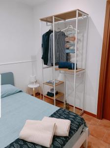 a bedroom with a bed and a rack of clothes at Appartamento Borgonuovo in Gallipoli