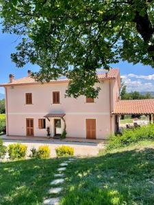 an exterior view of a large pink house at Villa del Colle Bevagna in Bevagna +38 photos