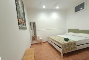 a white bedroom with a bed and a table at Appartamento Borgonuovo in Gallipoli