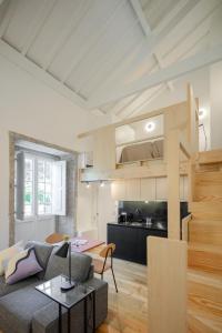 a living room with a couch and a kitchen at Gateway House Studio Apartments in Guimarães