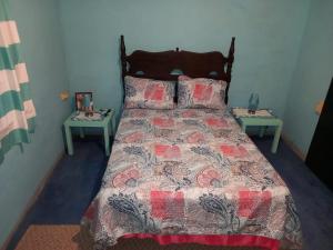 BUCKINGHAM VILLA -SUITES FULL KITCHEN-Rooms Variety في Buff Bay: غرفة نوم بسرير وطاولتين