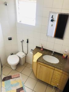 bagno con servizi igienici, lavandino e specchio di Triplex Cor de Chicletes a Curitiba