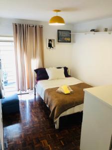 una camera da letto con un letto e un asciugamano giallo di Triplex Cor de Chicletes a Curitiba