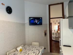 a room with a table and a tv on the wall at Apartment La Casa del Viaggiatore - 4 ppl - 13min to Milan - Free public parking in Trezzano sul Naviglio