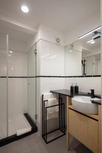 a bathroom with a sink and a glass shower at Gateway House Studio Apartments in Guimarães