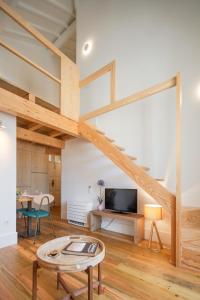 a living room with a staircase in a loft at Gateway House Studio Apartments in Guimarães