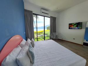 a bedroom with a large bed and a large window at Cardedeu Hotel Lago de Coatepeque in El Congo