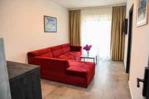 a red couch in a living room with a window at Apartments Montenegro Hills Ulcinj in Ulcinj