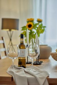 a bottle of wine and two wine glasses on a table at Exklusive Villa-Eggert mit Kamin & Terasse für 6 Personen im Bretten in Bretten