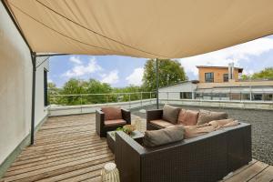 a patio with a couch and chairs on a deck at Exklusive Villa-Eggert mit Kamin & Terasse für 6 Personen im Bretten in Bretten +11 photos