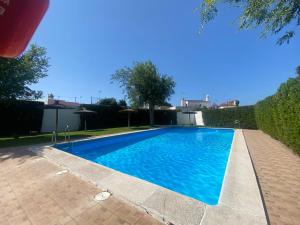 a swimming pool with blue water in a yard at Casa Doñana Golf in Matalascañas