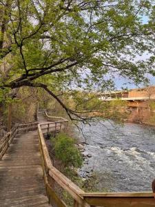 einen Holzweg neben einem Fluss mit einer Brücke in der Unterkunft Jennings in Cuyahoga Falls