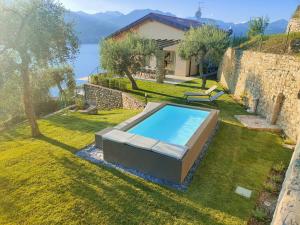 a swimming pool in a yard next to a house at Villa al Feudo in Brenzone sul Garda