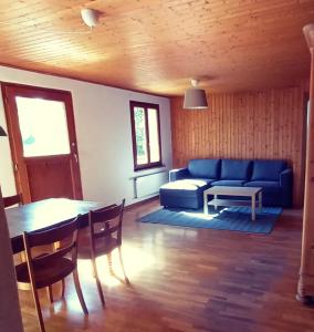 ein Wohnzimmer mit einem blauen Sofa und einem Tisch in der Unterkunft La Belle Etoile - Bauernhof in mitten der Natur 