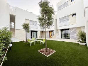 a garden with a tree in the middle of a building at Corte Cesarina in Porto Cesareo
