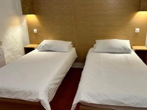 Duas camas num quarto com lençóis e almofadas brancos em Villa Valentina em Carvoeiro