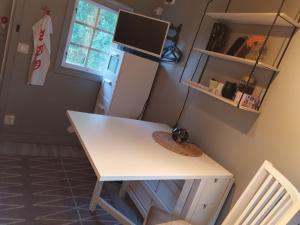 een wit bureau in een kamer met een koelkast bij Norrtälje in Norrtälje