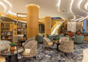 una hall di un hotel con tavoli e sedie di Embassy Suites By Hilton Doha Old Town a Doha