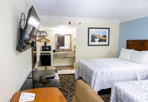 a hotel room with two beds and a table at Baymont by Wyndham College Park Atlanta Airport South in Atlanta