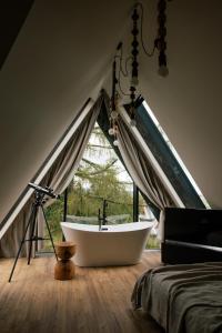 bañera blanca en una habitación con ventana en Slow Tatry Boutique Resort, en Zakopane