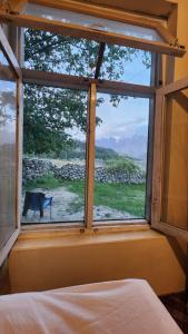 ein Schlafzimmerfenster mit Blick auf ein Feld in der Unterkunft Karakorum Family Guest House Hunza in Hunza