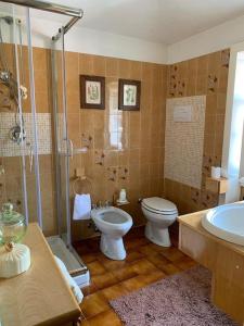 uma casa de banho com um WC, um chuveiro e um lavatório. em Ester Lakehouse, graziosa casa indipendente em Lierna