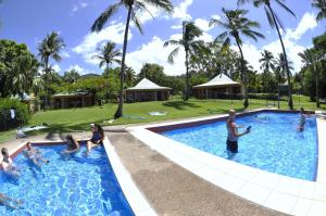 a swimming pool with a pool table and chairs at Nomads Airlie Beach in Airlie Beach