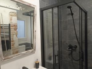 y baño con ducha y espejo. en Petra apartments -Old City with terrace and barbecue-, en Tarragona