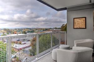 a balcony with white chairs and a view of a city at Outstanding Luxury Downtown Condo in Asheville