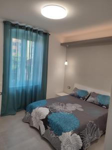 una camera da letto con un letto con tende blu e una finestra di La Casa di Linda a Genova