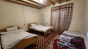 سرير أو أسرّة في غرفة في Karakorum Family Guest House Hunza