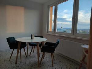 mesa y sillas en una habitación con ventana en sky apartment, en Prievidza