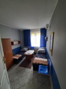 a room with two beds and a table and chairs at Willa Elżbieta in Rewal
