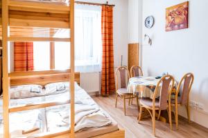 a dining room with a table and a bunk bed at Apartmány Červenohorské sedlo in Kouty