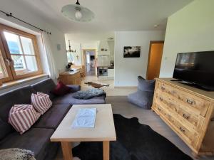 ein Wohnzimmer mit einem Sofa und einem Flachbild-TV in der Unterkunft Landhaus Tirol in Hopfgarten im Brixental