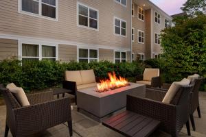 a fire pit in the middle of a patio with chairs at Residence Inn Boston Franklin in Franklin