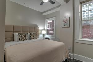 a bedroom with a large bed and two windows at Historic King James Unit 5 in Asheville