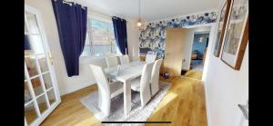 een eetkamer met een witte tafel en stoelen bij Ormasaig, Self Catering, One Mile to Town & close to Ben Nevis in Fort William