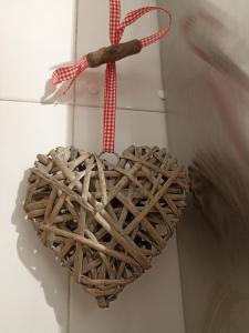 a wicker heart ornament hanging on a wall at Petra apartments -Old City with terrace and barbecue- in Tarragona