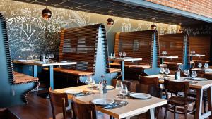 ケルステルバッハにあるHey Lou Hotel Frankfurt Airportのテーブルと椅子、壁の落書きが楽しめるレストラン
