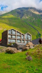 budynek na szczycie wzgórza z górą w obiekcie Step Inn - Kazbegi w mieście Stepancminda