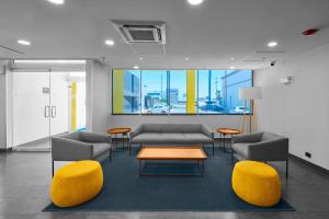 a waiting room with couches and a table and chairs at City Express by Marriott Ciudad Juárez in Ciudad Juárez