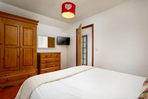 a bedroom with a white bed and a wooden cabinet at The Roundhouse in Launceston