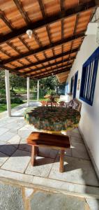 ławka pod drewnianym dachem na patio w obiekcie Estância Morro Do Frota w mieście Pirenópolis