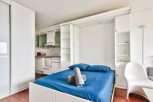 a bedroom with a blue bed and white cabinets at Studio - Appartement Quartier Montmartre in Paris