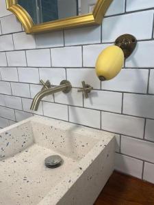 a bathroom sink with a light and a mirror at *•*•Nouveau*•*• Chez Mirabelle in Belleville-sur-Meuse