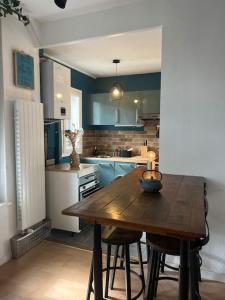 une cuisine avec une table en bois et quelques placards bleus dans l'établissement *•*•Nouveau*•*• Chez Mirabelle, à Belleville-sur-Meuse