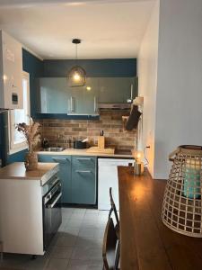 une cuisine avec des placards bleus et une table en bois dans l'établissement *•*•Nouveau*•*• Chez Mirabelle, à Belleville-sur-Meuse
